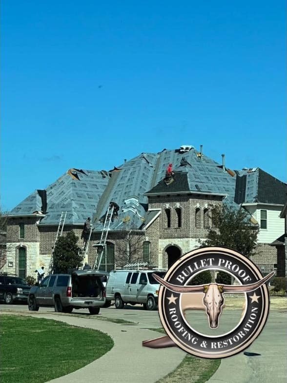 Crew laying synthetic underlayment across a full roof replacement